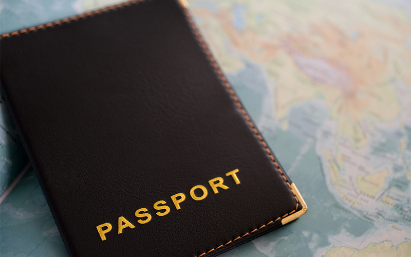 Black passport with map in the background